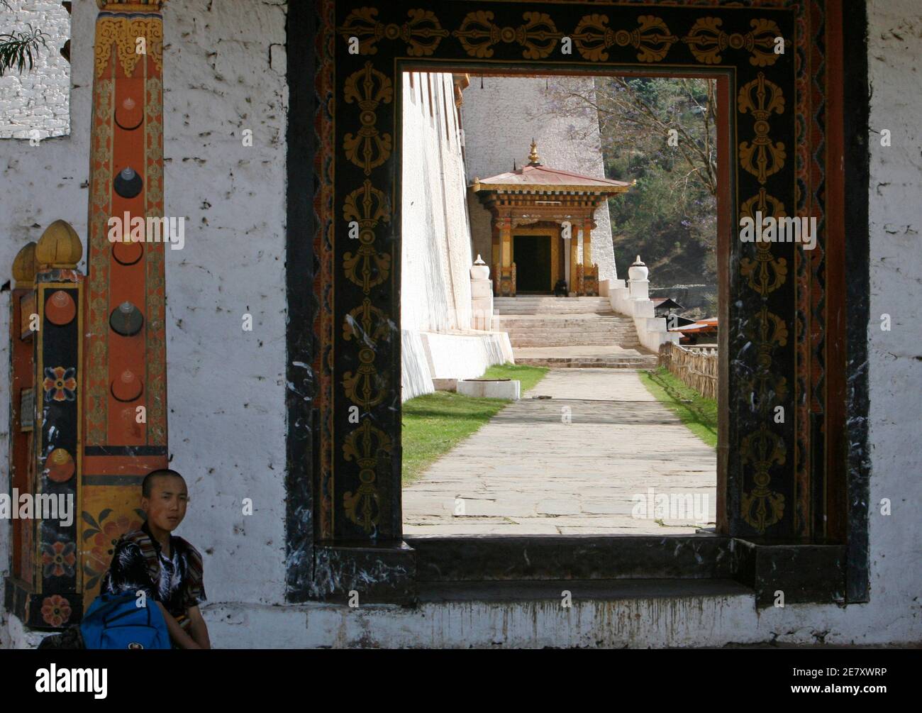 Ein Mann sitzt am Eingang von Dzong, einer Festung in Punakha 19. April 2007. Erst in den 1960er Jahren hatte Bhutan keine Straßen und praktisch keine Schulen oder Krankenhäuser. Heute sind Bildung und Gesundheitsversorgung kostenlos, und die Lebenserwartung ist auf 66 Jahre gestiegen, von weniger als 40, eine Tatsache, die die meisten Menschen der königlichen Herrschaft zuschreiben. Bild aufgenommen am 19. April 2007. REUTERS/Desmond Boylan (BHUTAN) Stockfoto