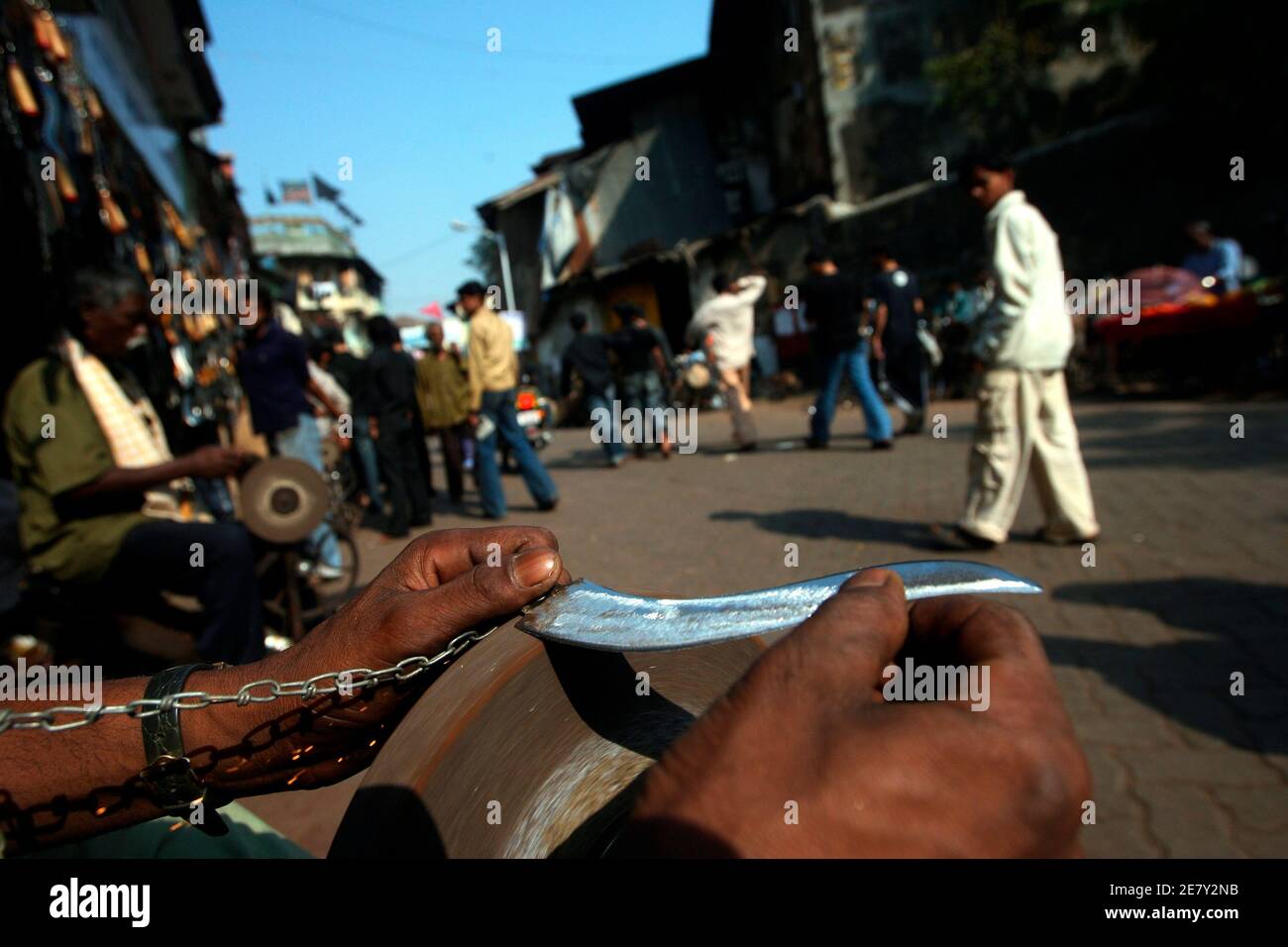 Ein Mann schärft eine Klinge angebracht zu einer Kette für Selbstgeißelung Rituale während Ashura, in den alten Vierteln von Mumbai 7. Dezember 2009 verwendet werden. Ashura, ein Zeitraum von 10 Tagen der Trauer im islamischen Monat Muharram, erinnert an den Tod von Imam Hussein, Prophet Mohammad Enkel, in der 7. Jahrhundert Schlacht von Kerbela. REUTERS/Arko Datta (Indien) Stockfoto