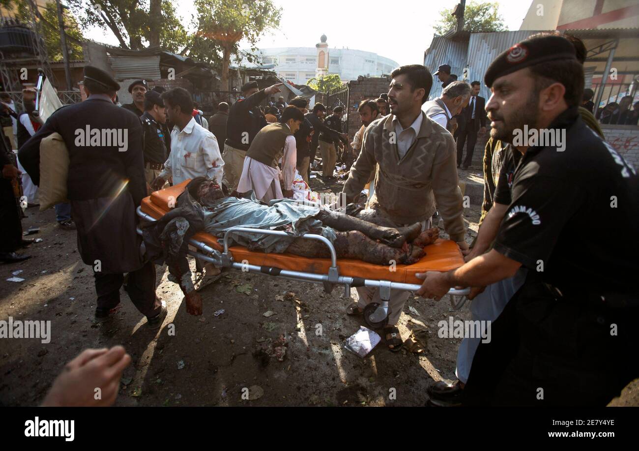 ACHTUNG EDITOREN - VISUELLE BERICHTERSTATTUNG SZENEN VERLETZUNGEN ODER TOD. Polizei und Freiwillige bringen die Toten am 19. November 2009 vor einem Gerichtsgebäude in Peschawar an der Stelle einer Selbstmordbombe. Ein Selbstmordattentäter sprengte sich am Donnerstag vor einem Gerichtsgebäude in Peshawar in die Luft und tötete mindestens 15 Menschen, sagten Beamte, in der jüngsten Folge einer Reihe von Angriffen auf die nordwestliche pakistanische Stadt. REUTERS/FAISAL MAHMOOD (PAKISTAN KONFLIKT KRIMINALITÄT GESETZ BILDER DES TAGES) Stockfoto