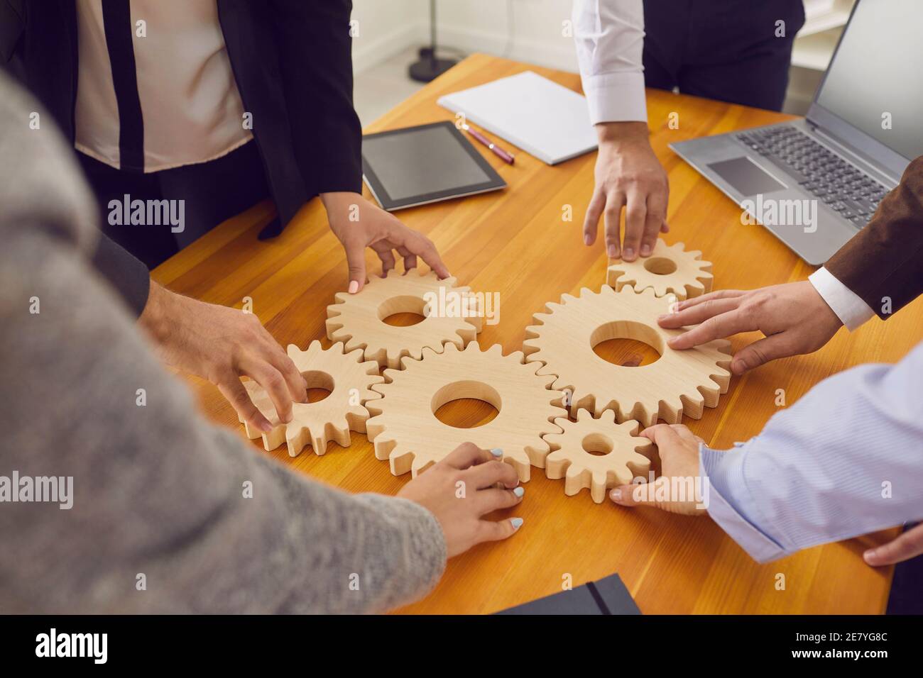 Firmenmitarbeiter verbinden Zahnräder als Metapher für Teamarbeit, Geschäftssystem und Arbeitslösungen Stockfoto