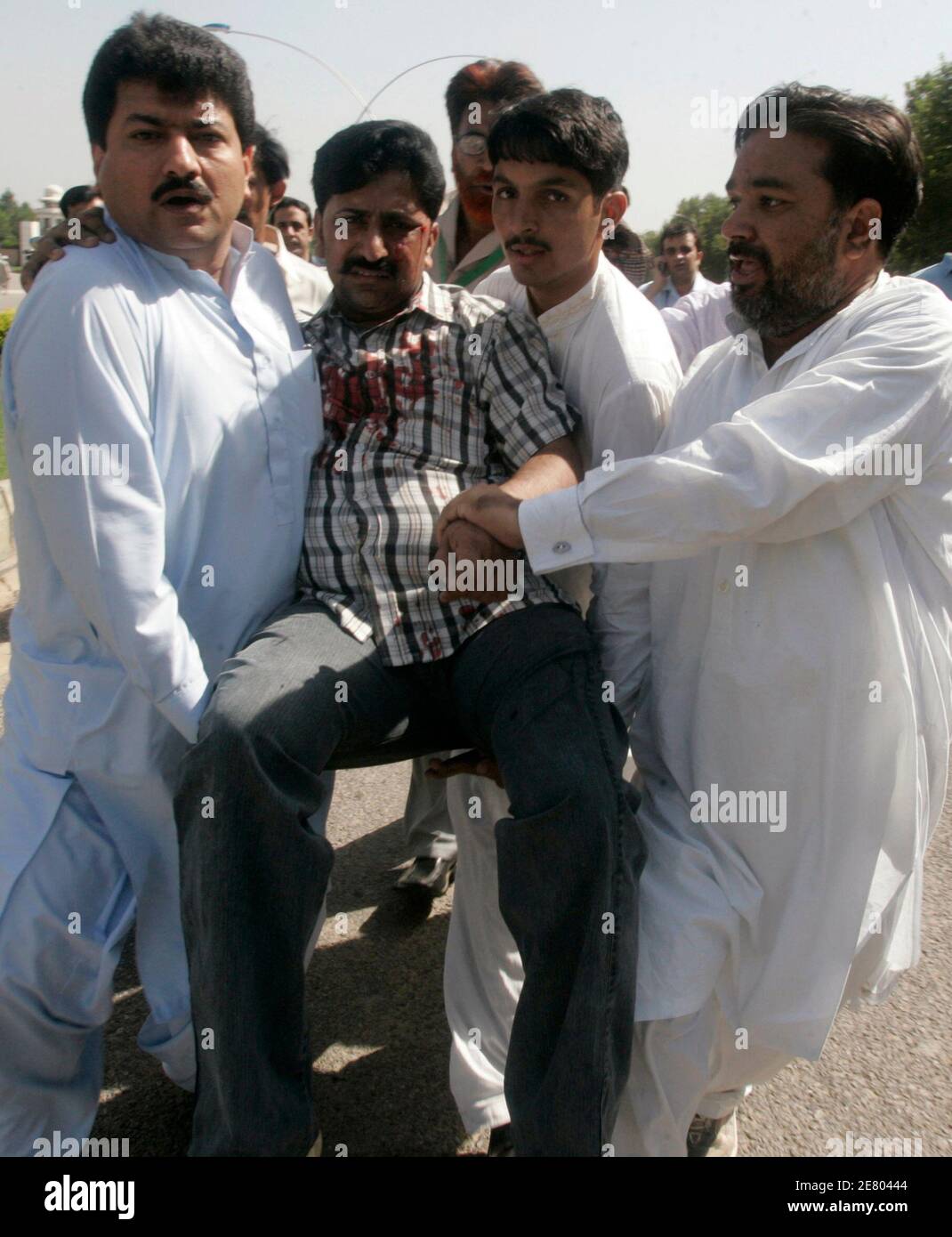 Pakistanischen Journalisten helfen einen verletzten Kollegen nach einem Zusammenstoß zwischen Anwälten und der Polizei in Islamabad 29. September 2007. Pakistanische Polizei mit Schlagstöcken und feuert Tränengas kollidierte am Samstag mit Anwälte und Aktivisten gegen Präsident Pervez Musharraf als die Wahlkommission akzeptiert seine Nominierung für eine 6. Oktober Abstimmung.     REUTERS/Faisal Mahmood (PAKISTAN) Stockfoto