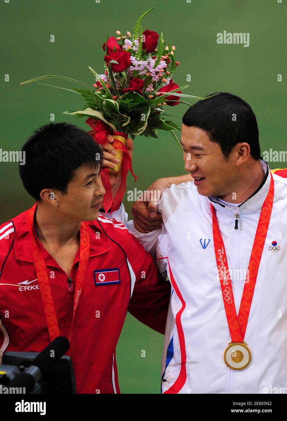 Goldmedaillengewinner Jin Jong Oh (R) der Republik Korea spricht mit Silbermedaille Kim-Jong-Su (L) von Nordkorea auf dem Podium nach die Männer 50m Pistole schießen endgültig auf die Beijing 2008 Olympischen Spiele August 12, 2008.     REUTERS/Desmond Boylan (CHINA) Stockfoto