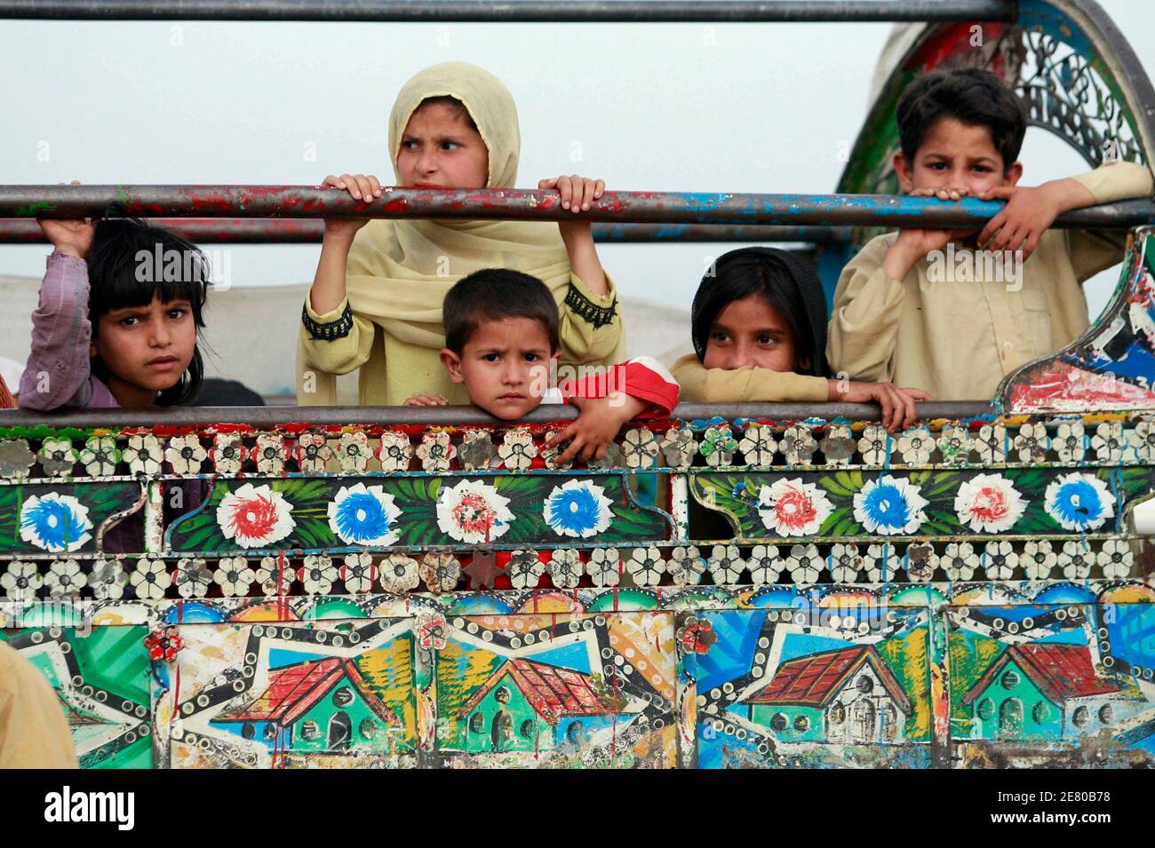 Intern vertriebene Kinder, die vor militärischen Operationen in Buner fliehen, sitzen in einem Van, als sie in einem UNHCR-Lager (Hochkommissariat für Flüchtlinge der Vereinten Nationen) im Distrikt Swabi ankommen, etwa 150 km (85 Meilen) nordwestlich von Pakistans Hauptstadt Islamabad, 7. Mai 2009. Sicherheitskräfte starteten am 26. April eine Offensive, um Militante aus zwei Nachbarbezirken Swats, Dir und Buner, zu vertreiben.Seitdem hat sich die Sicherheit in Swat stark verschlechtert. REUTERS/Faisal Mahmood (PAKISTAN SOCIETY POLITICS CONFLICT) Stockfoto