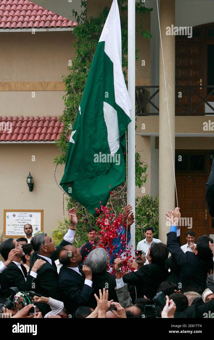 Anwälte und politischen Aktivisten teilnehmen an einer Fahne heben Zeremonie außerhalb der Residenz von Pakistans wieder eingesetzte Oberrichter Iftikhar Chaudhry in Islamabad 22. März 2009. Chaudhry fortgesetzt Büro am Sonntag, eine Woche, nachdem die Regierung angekündigt, dass es ihm Einhalt zu einem Massenprotest Rechtsanwälte und Oppositionsparteien geordnet wieder herzustellen war.   REUTERS/Faisal Mahmood (PAKISTAN-Politik-Konflikt) Stockfoto