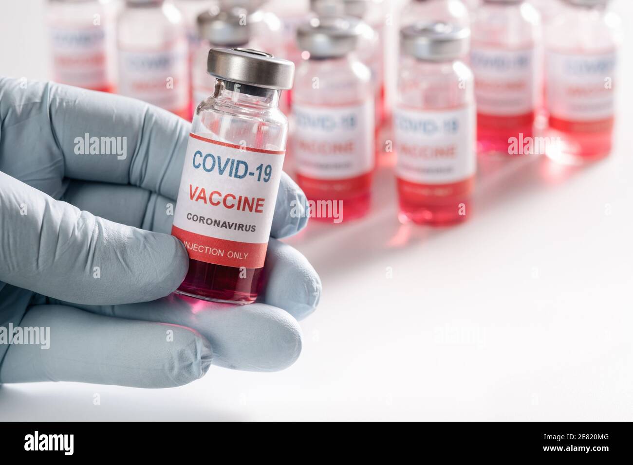 Impfstofffläschchen in Nahaufnahme der menschlichen Hand und viele Glasflaschen Stockfoto