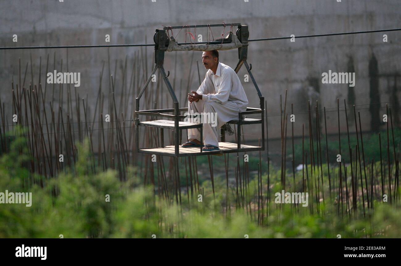 Ein Mann sitzt in einer Seilbahn, da er über eine Bayou in Rawalpindi nahe der pakistanischen Hauptstadt Islamabad 3. Mai 2009 transportiert wird.  REUTERS/Faisal Mahmood (PAKISTAN SOCIETY) Stockfoto