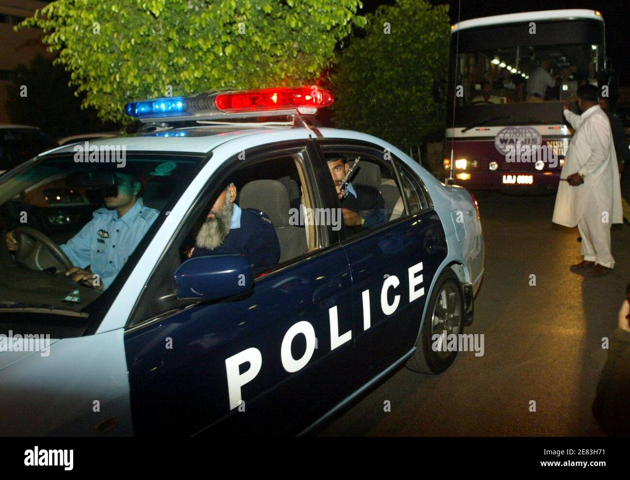 Pakistanische Polizisten eskortieren einen Bus mit England Cricket-Team-Spieler nach ihrer Ankunft in Pakistan Islamabad International Airport 26. Oktober 2005. Das Team kam vor ihrer Wintertour nach Pakistan und sollen drei Tests und fünf One-Day Internationals spielen. Der erste Test in Multan startet am 12. November. REUTERS/Faisal Mahmood Stockfoto
