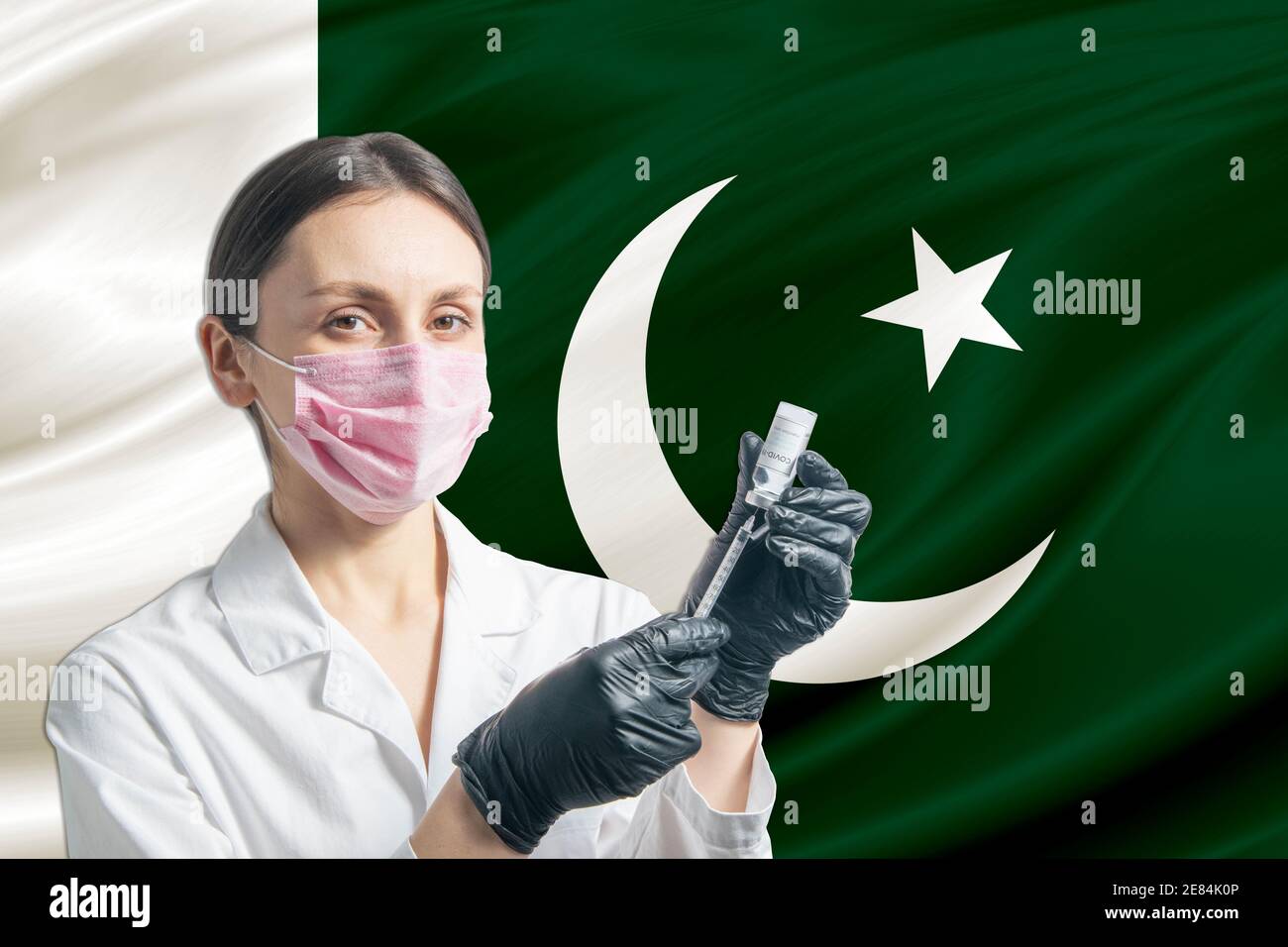 Ärztin bereitet die Impfung vor dem Hintergrund der pakistanischen Flagge vor. Impfkonzept Pakistan. Stockfoto