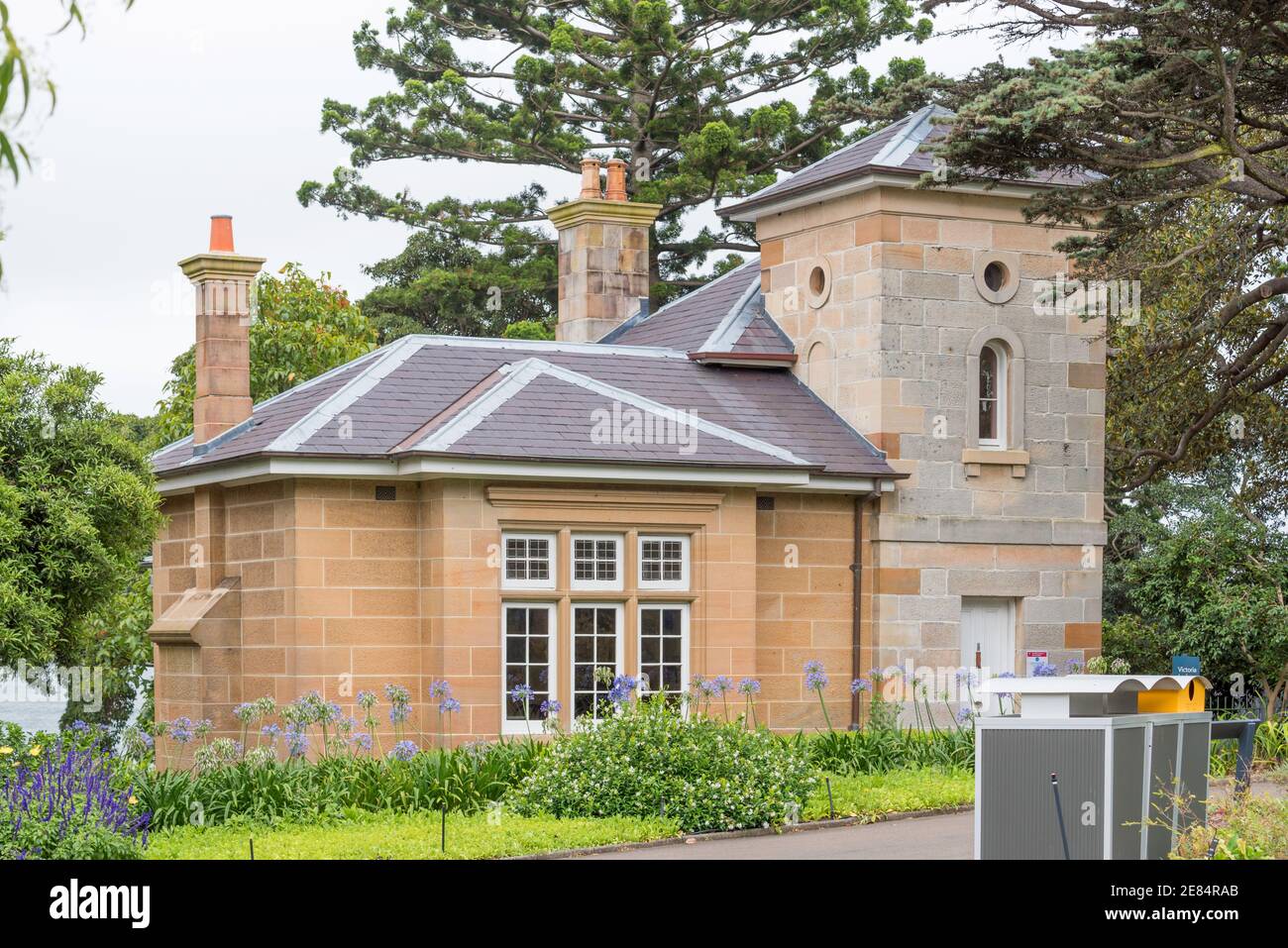 Die Victoria Lodge in den Royal Botanic Gardens Sydney, Australien wurde 1865 aus lokalem Sandstein- und Schieferdach erbaut und 1897 erweitert Stockfoto