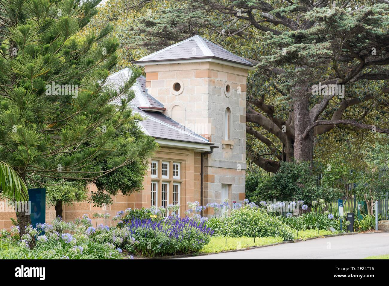 Die Victoria Lodge in den Royal Botanic Gardens Sydney, Australien wurde 1865 aus lokalem Sandstein- und Schieferdach erbaut und 1897 erweitert Stockfoto