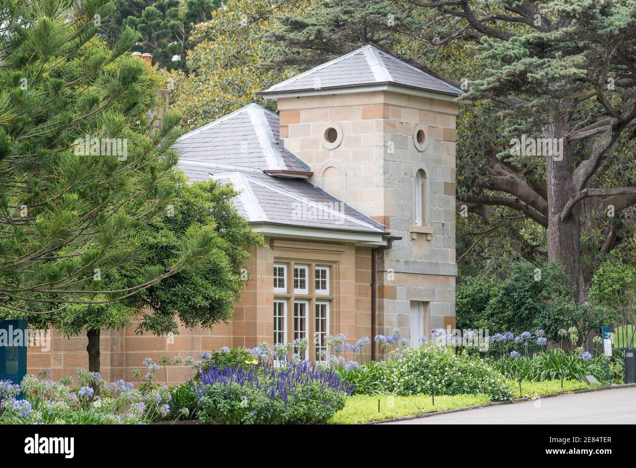 Die Victoria Lodge in den Royal Botanic Gardens Sydney, Australien wurde 1865 aus lokalem Sandstein- und Schieferdach erbaut und 1897 erweitert Stockfoto