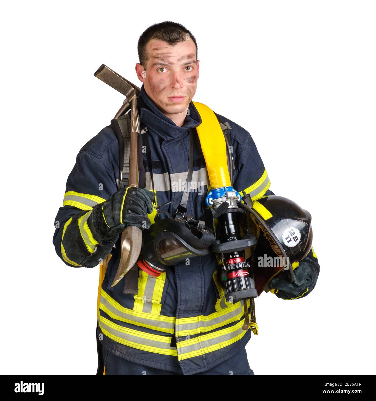 Mann in Feuerwehruniform hält Hardhut, Quetschstange, Feuerwehrschlauch Stockfoto