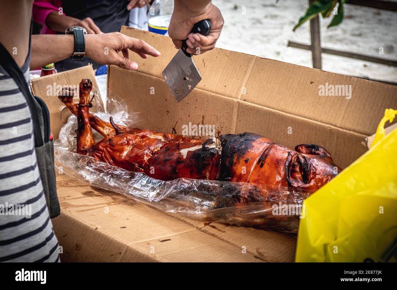 Im Urlaub in Davao City Philippines wird man das köstliche Lechon (gebratenes Schweinefleisch) essen. Wundervolle Zeit am Strand. Zerkleinern von Lebensmitteln. Stockfoto