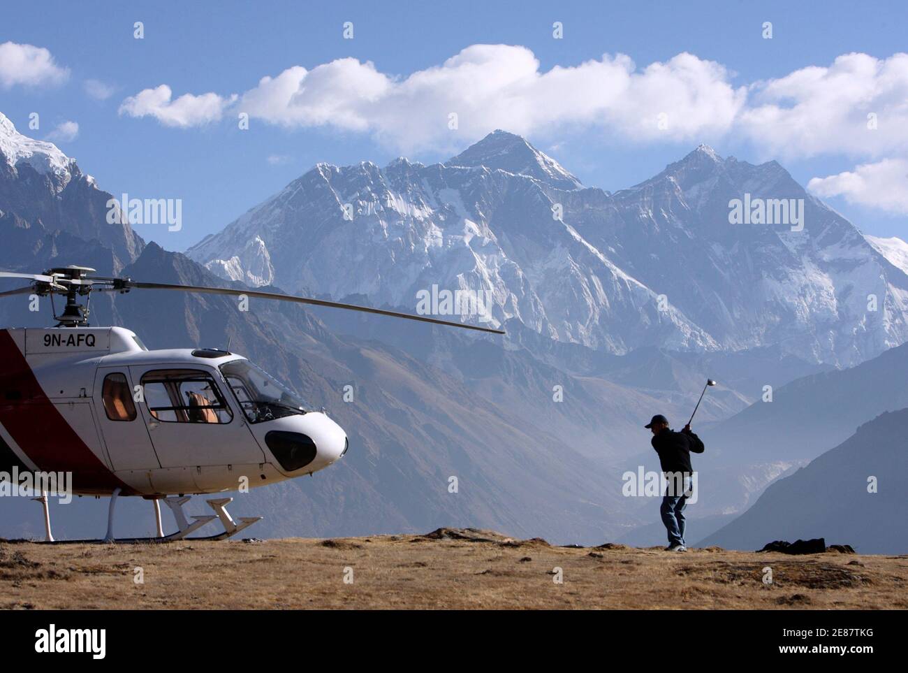 Ang Tshring Sherpa spielt einen Schuss in Kongde 5. März 2009. Der Amateurgolfer Ang Tshring, der Besitzer von Nepals größter inländischer Fluggesellschaft Yeti Airways, mietete einen Hubschrauber, um den Ort zu erreichen, da er seinen Golf an einem anderen Ort üben wollte. Ang Tshring, der ein Handicap von sieben hat, will Tiger Woods einladen, an diesem Ort, der mehr als 4,420 Meter (14,500 Fuß) über dem Meeresspiegel liegt, ein paar Schüsse zu spielen. Der Mount Everest, der höchste Gipfel der Welt mit 8,848 Metern (29,029 ft), ist im Hintergrund zu sehen. REUTERS/Gopal Chitrakar (NEPAL) Stockfoto