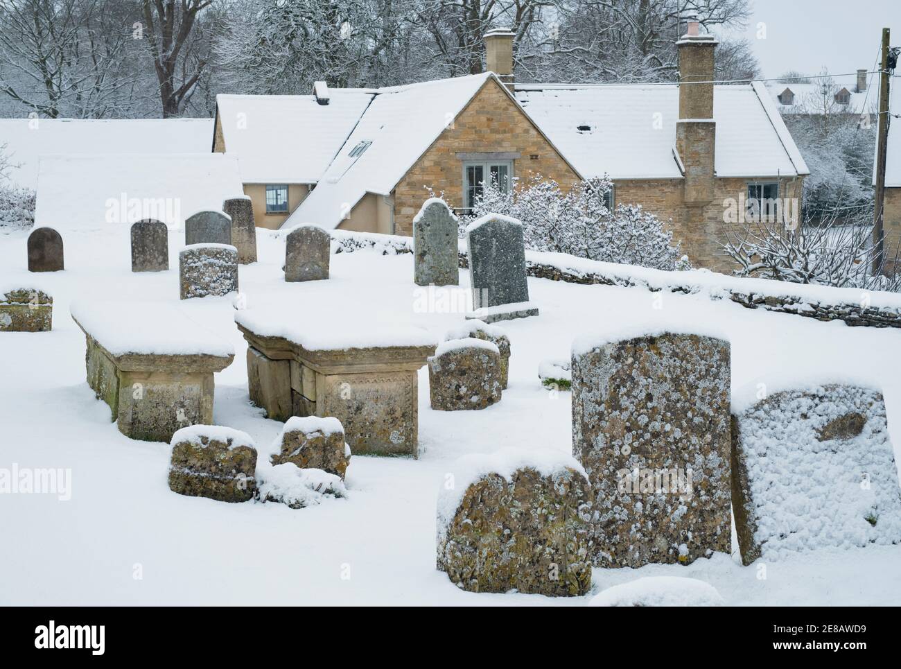 Grabsteine in St. Marys Kirchhof im Schnee. Swinbrook, Cotswolds, Oxfordshire, England Stockfoto