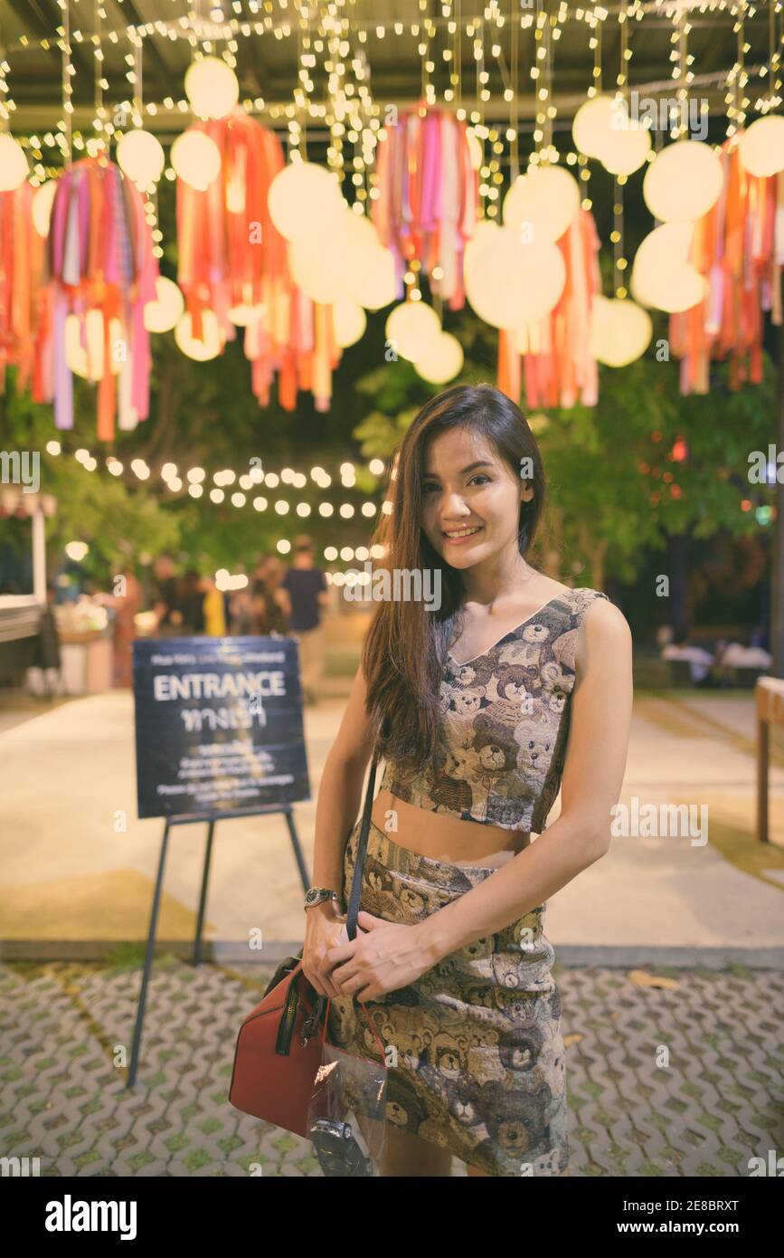 Junge glücklich schöne asiatische Frau lächelnd und am Eingang der offenen Live Band in der Nachtmarkt von Hua Hin Thailand Stockfoto