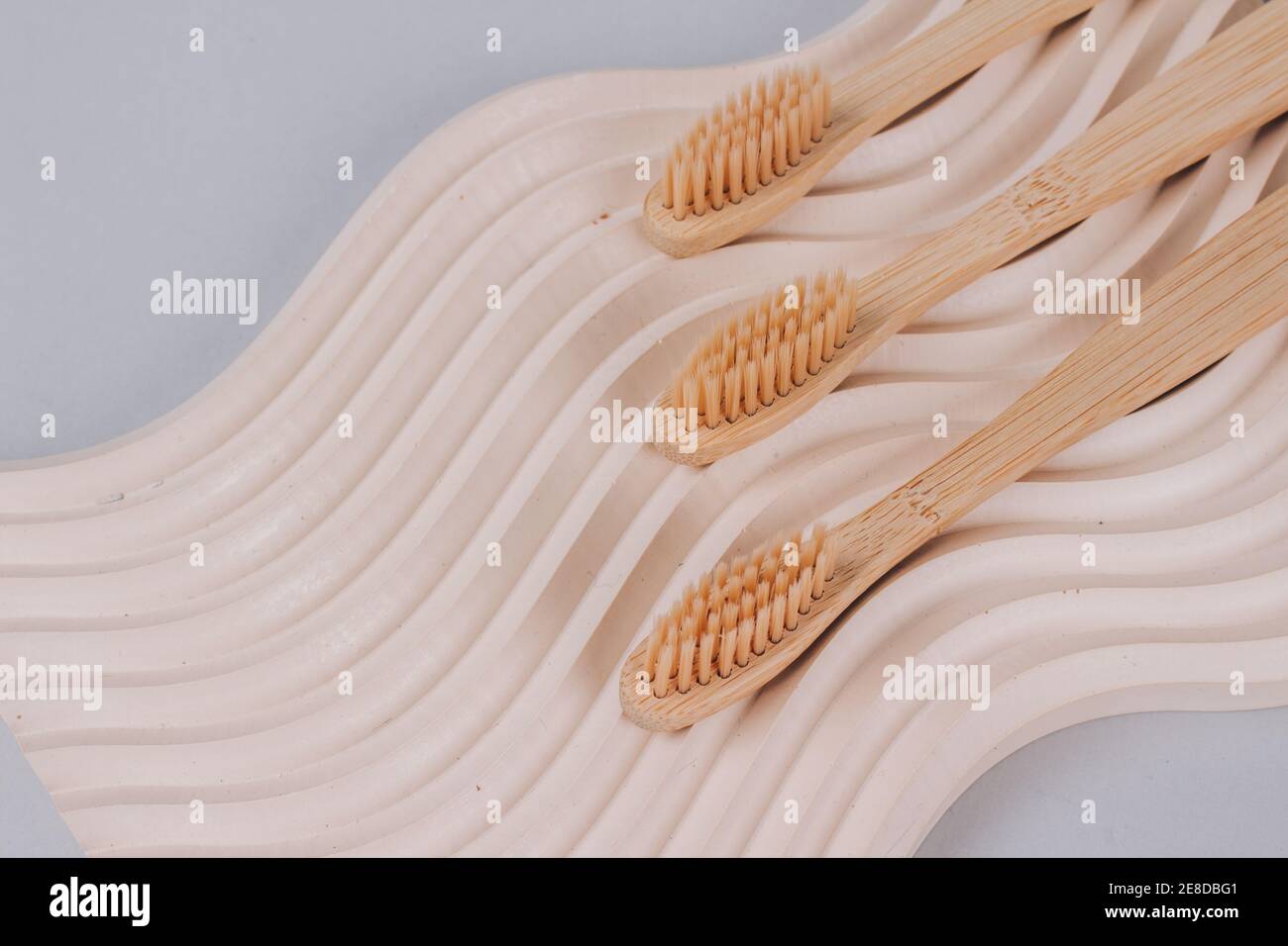 Trendige Stillleben Komposition mit natürlichen Bambus Zahnbürsten auf welligen Gipsform Hintergrund mit Kopierraum. Nachhaltiger Lebensstil, Null-Abfall-Haus Stockfoto