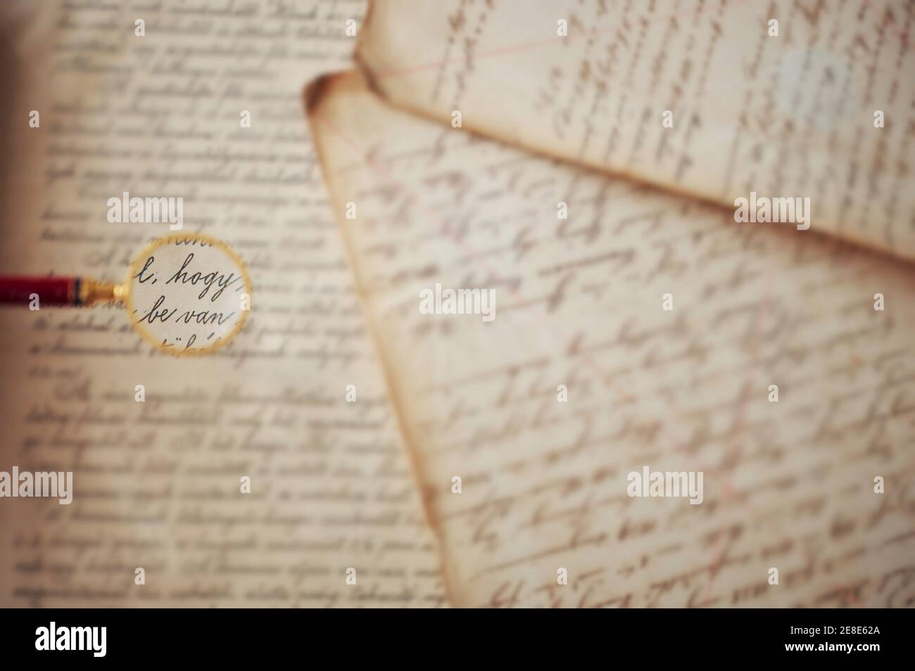 Nicht erkennbare alte Vintage-Handschrift mit Lupe Stockfoto