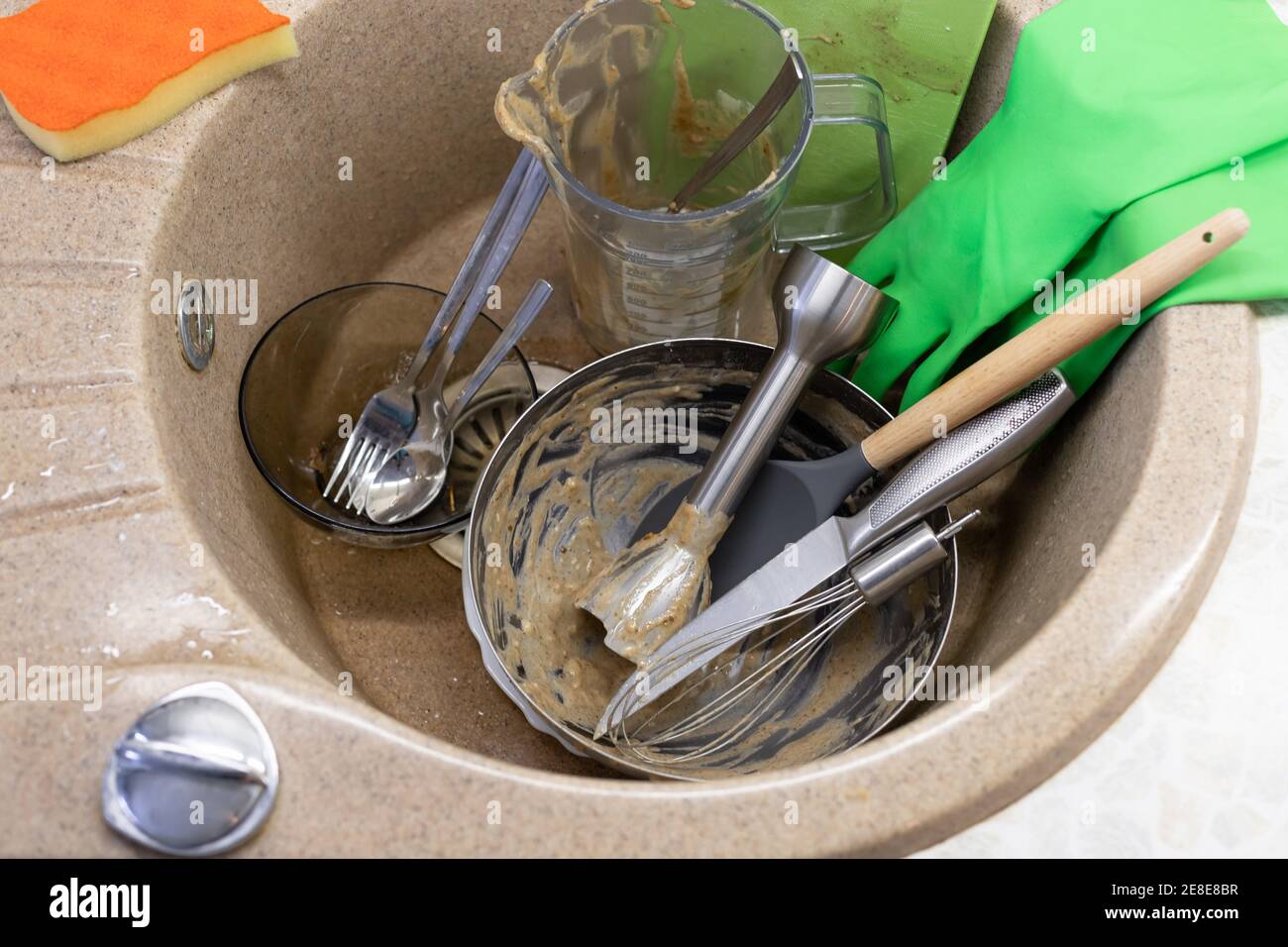Ungewaschene Geschirr und Utensilien in Spülbecken, Latexhandschuhe und Waschschwamm Stockfoto