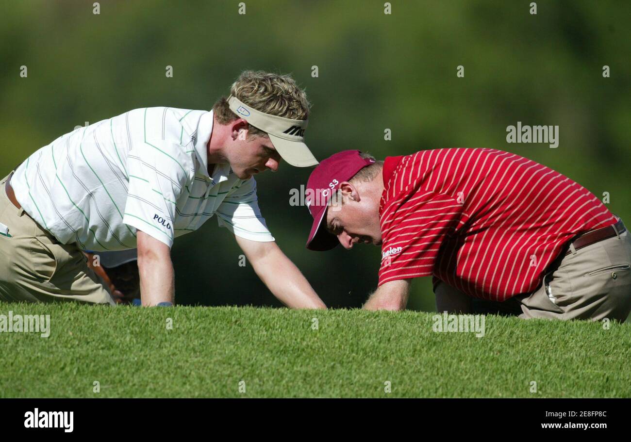 Jim Furyk der USA hilft Großbritanniens Luke Donald (L) Suche nach seinen Ball am 16. Loch während der dritten Runde der $ 4 Millionen Sun City Golf Challenge in Sun City, westlich von Johannesburg in Südafrika 3. Dezember 2005. REUTERS/Juda Ngwenya Stockfoto