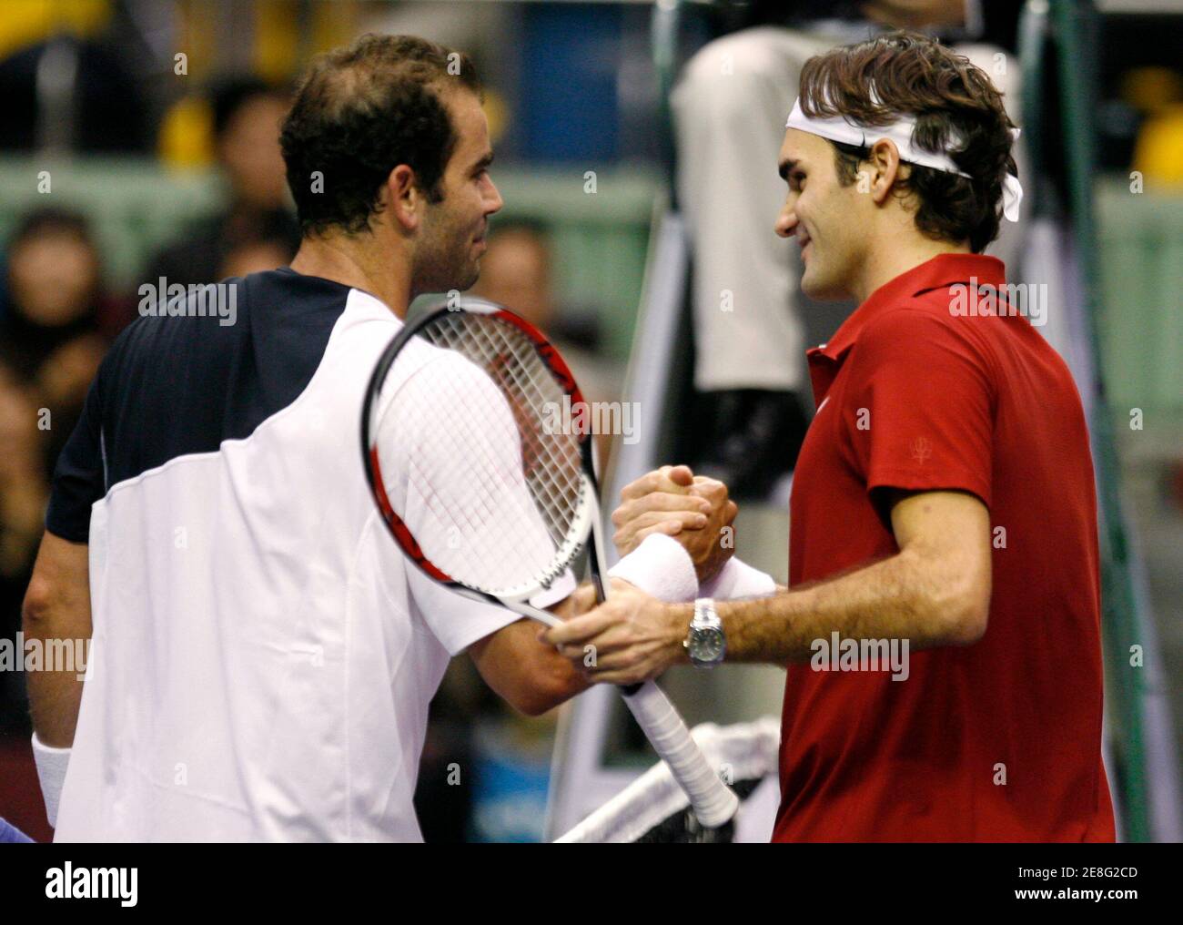 Roger Federer von Switzerland (R) und Pete Sampras der USA halten Sie Hände, nachdem ihre invitational Ausstellung Tennismatch in Seoul 20. November 2007. Federer gewann das Spiel. REUTERS/Jo Yong-Hak (Südkorea) Stockfoto
