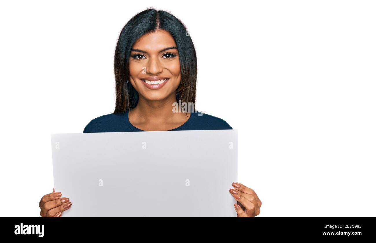Junge lateinische transsexuelle Transgender Frau mit leerem leeren Banner suchen Positiv und glücklich stehen und lächeln mit einem selbstbewussten Lächeln Anzeige t Stockfoto
