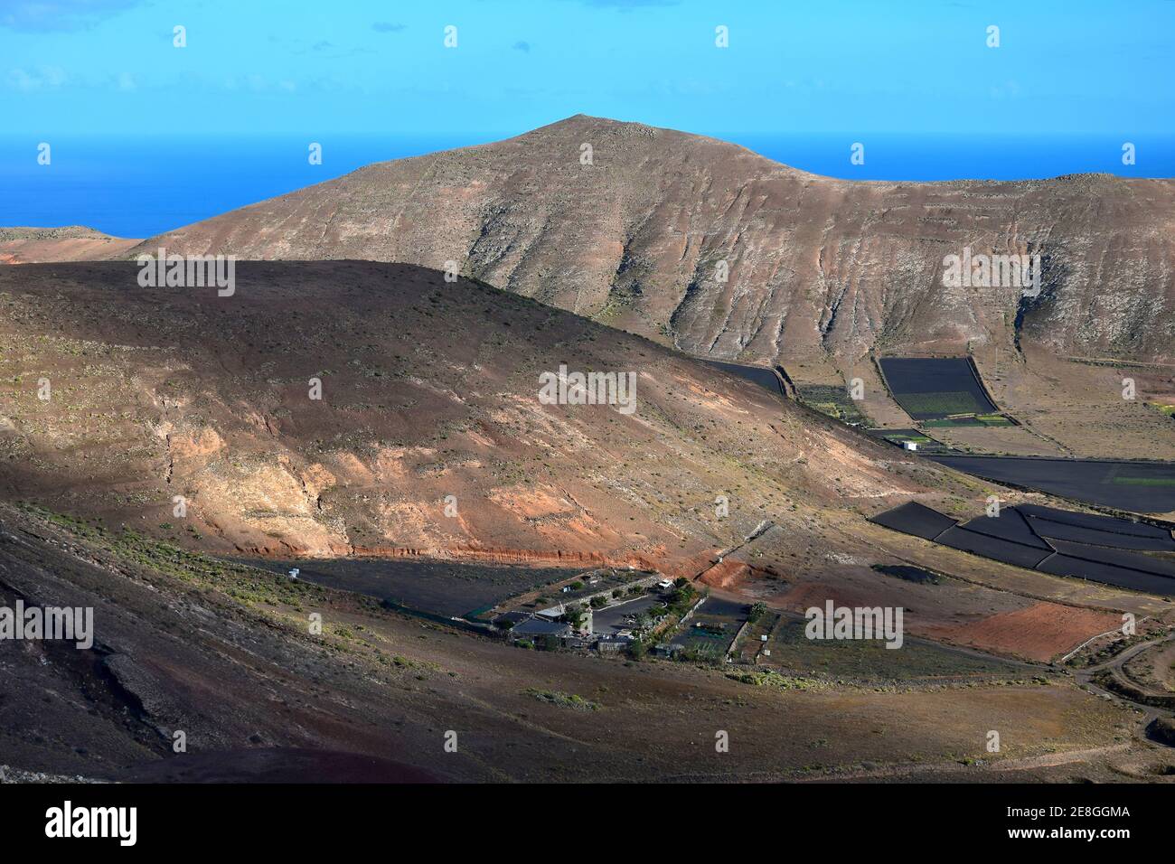 Blick auf ein Tal mit Feldern für die Landwirtschaft. Im Hintergrund die Bergkette Los Ajaches. In Der Nähe Von Femés. Lanzarote, Spanien. Stockfoto