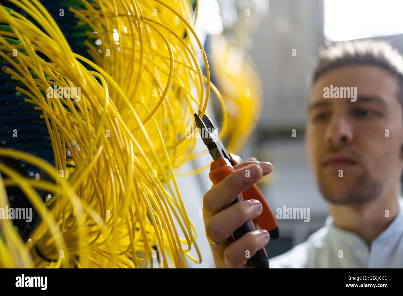 Von unten verschwommen männlichen Techniker mit Drahtschneider arbeiten mit Elektronisches System des Serverraums Stockfoto
