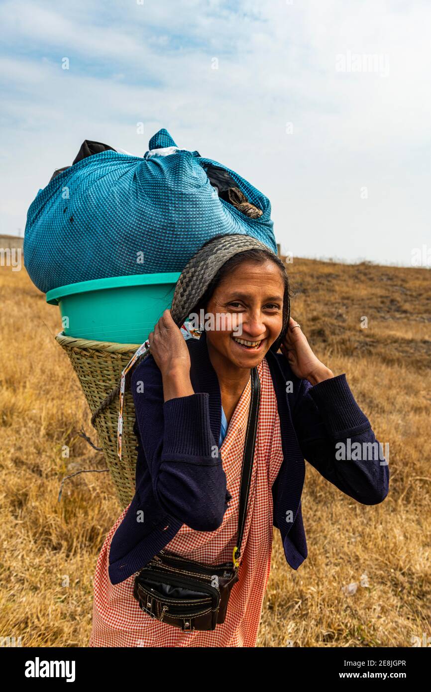 Khasi-Frau, die die Wäsche in einem traditionellen Korb zu einem Bach trägt, Meghalaya, Indien Stockfoto