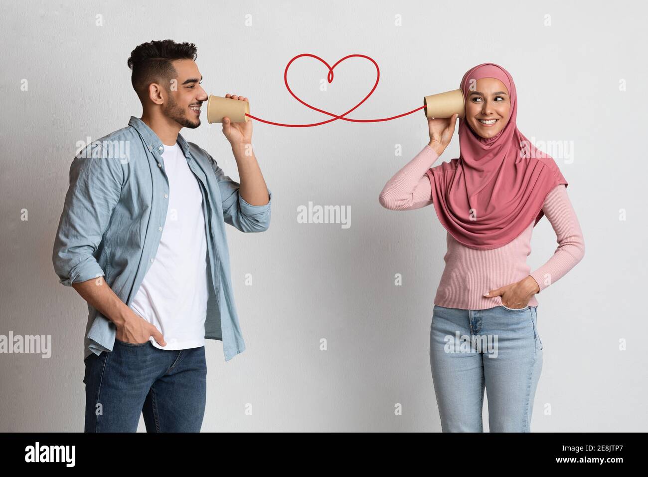 Romantischer Kerl sendet Liebesbotschaft an muslimische Freundin durch Papier tasse Telefon Stockfoto