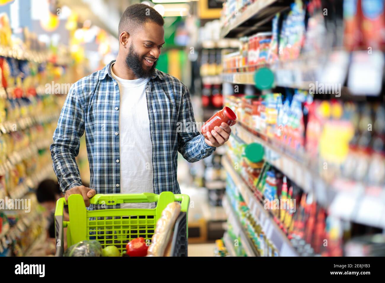 Mann, Der Lebensmittel Einkaufen Stehen Mit Warenkorb Auswahl Essen Im Innen Stockfoto