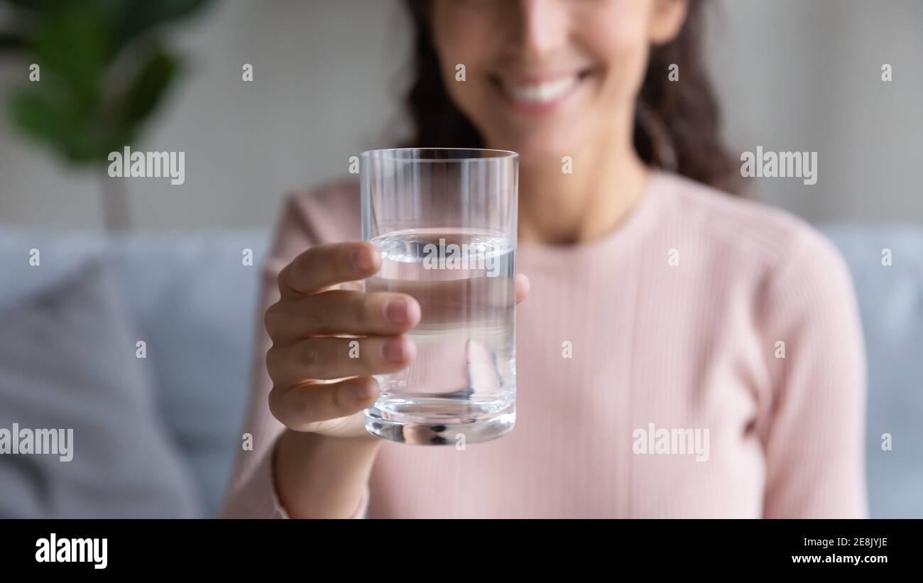 Nahaufnahme des Glases mit sauberem Mineralwasser in weiblichen Händen. Stockfoto