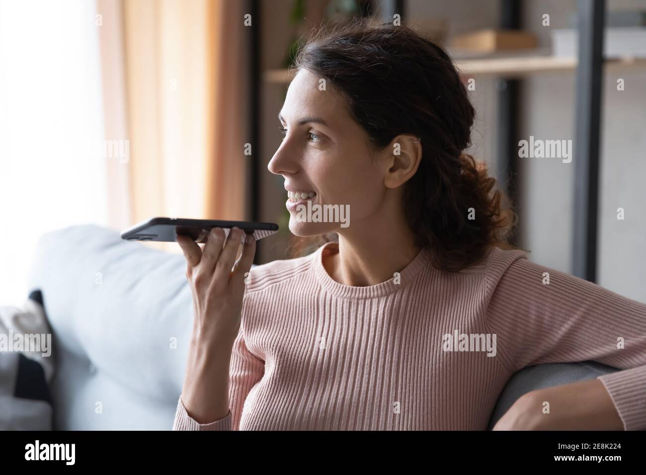 Glücklich verträumt junge Frau Aufnahme Audio-Nachricht. Stockfoto