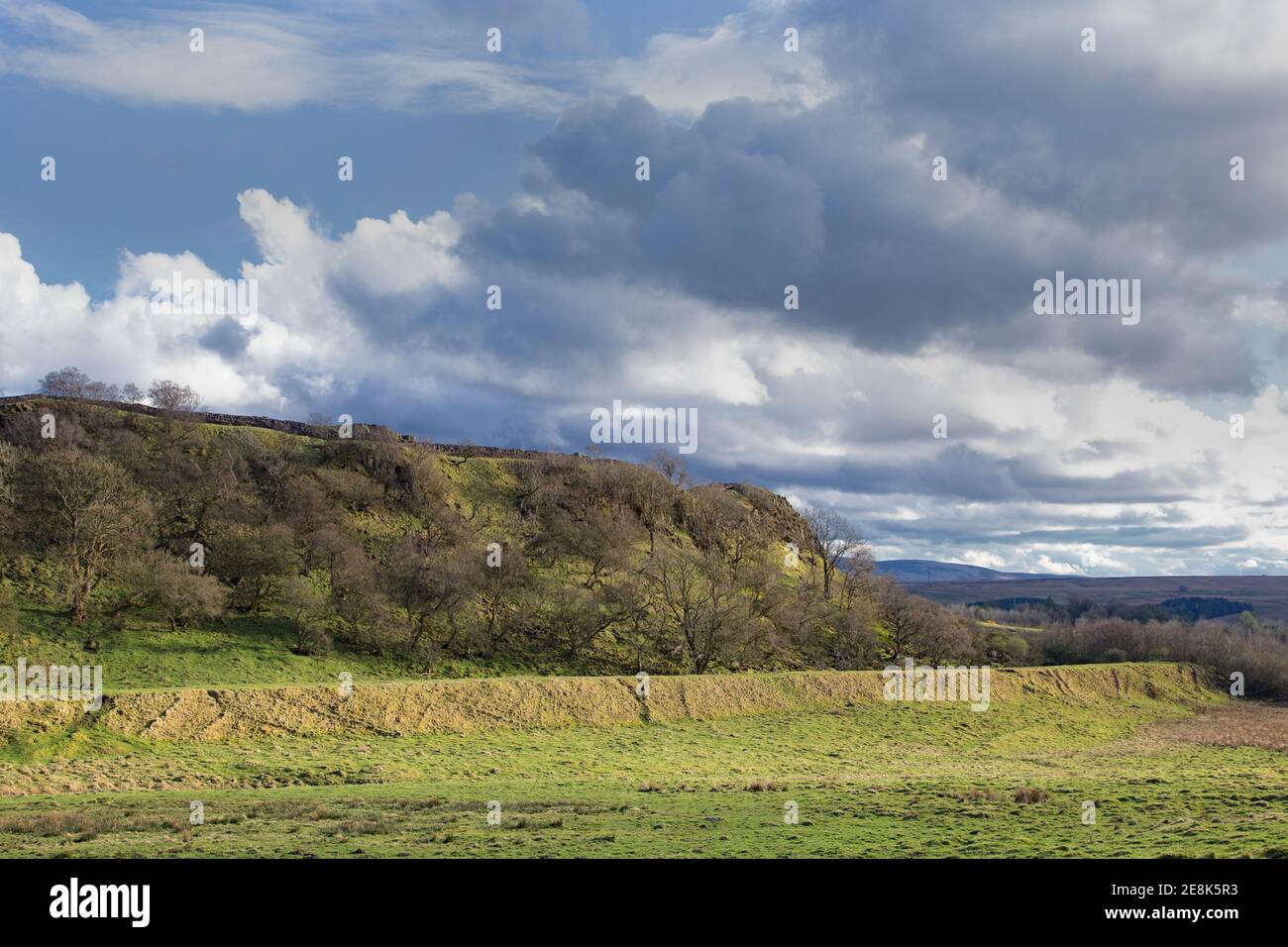 Die Nordwand der Walltown Crags mit an ihrer Basis, die Überreste einer alten Bahnstraße, die Greenhead Quarry, Hadrian's Wall, Northumberland, Großbritannien führte Stockfoto