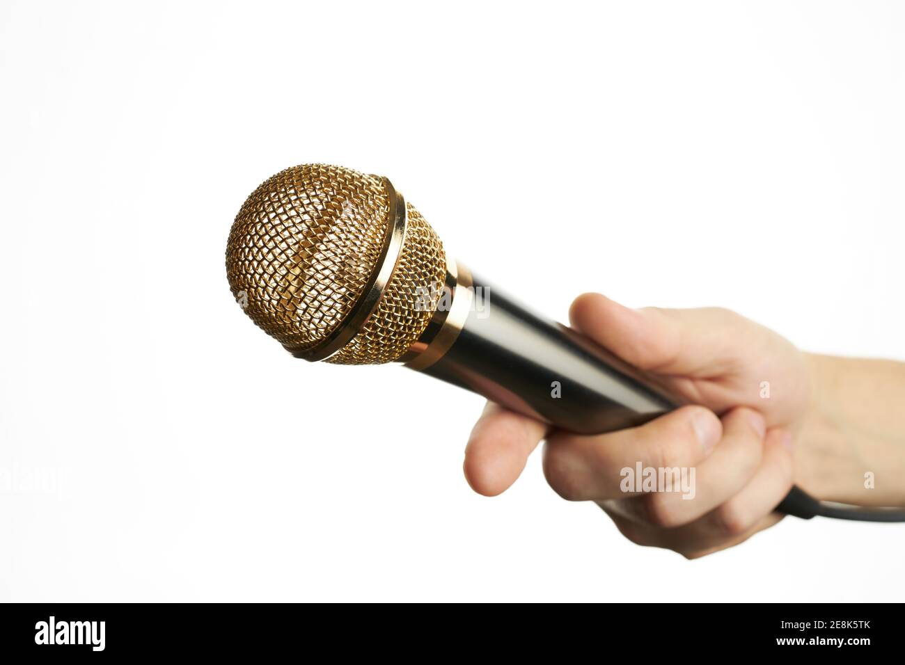 Männliche Person hält goldenes Mikrofon isoliert auf einem weißen Hintergrund. Interviewkonzept. Für Design oder Dekoration Stockfoto