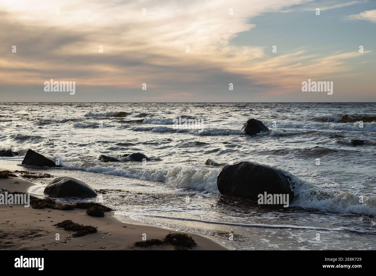 Große Steine im Wasser am Strand der Ostsee, Lettland Stockfoto