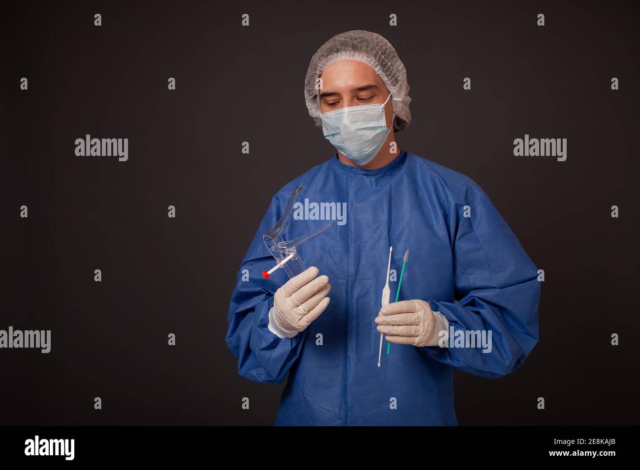Ein Gynäkologe mit einem venusspiegel in den Händen. Gynäkologisches  Zubehör, Pinsel, Stick. Ein Arzt in einer medizinischen Maske, eine Robe,  Handschuhe, ein Hut mit einem gyn Stockfotografie - Alamy