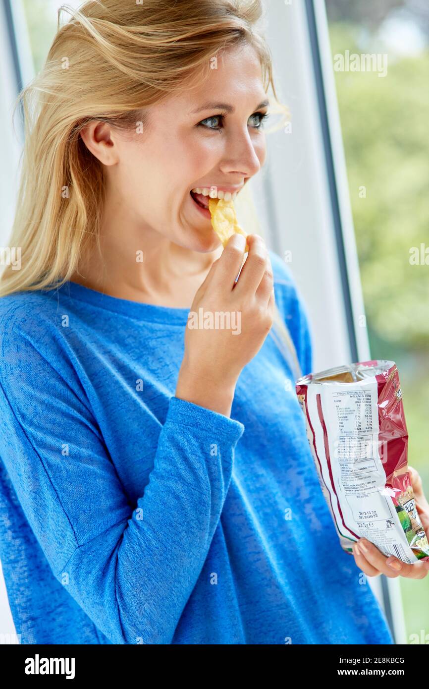 Mädchen essen eine Tüte Chips Stockfoto