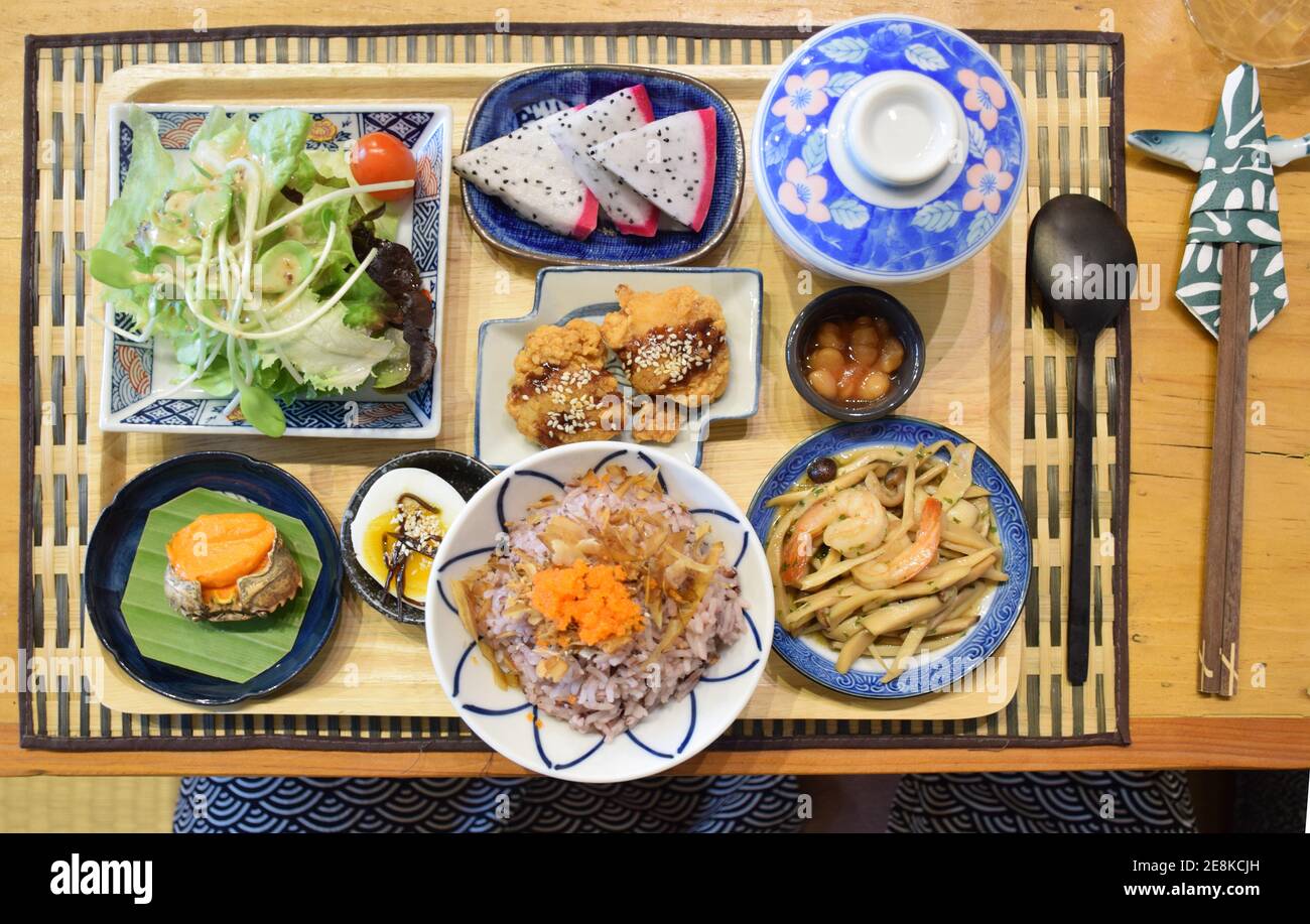 Blick von oben auf das japanische Frühstück (frisches Gemüse, Natto, Reis, Karaage-Huhn, gebratene Pilze, gekochte Eier Stockfoto