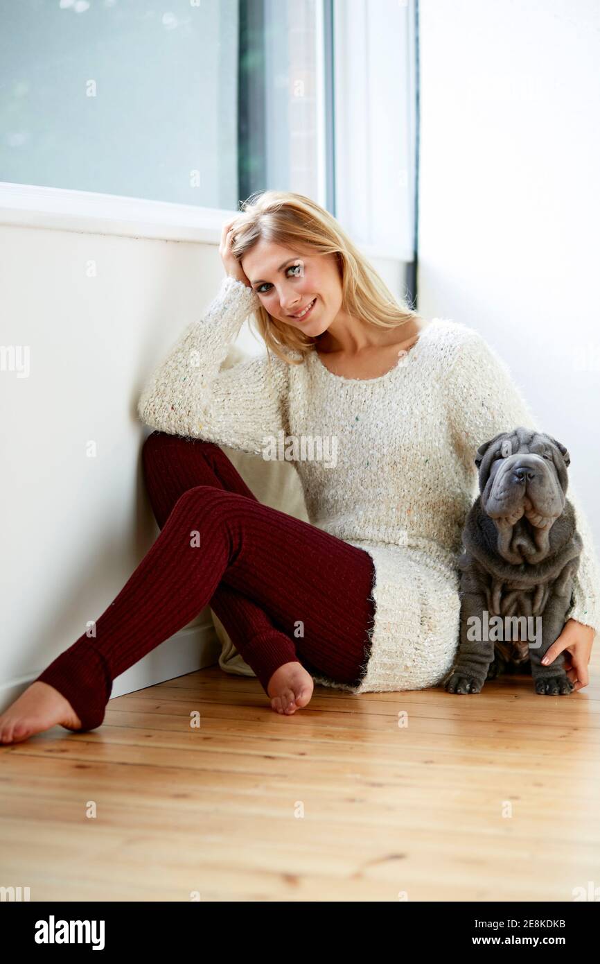 Schöne blonde Frau saß mit ihrem Hund Stockfoto