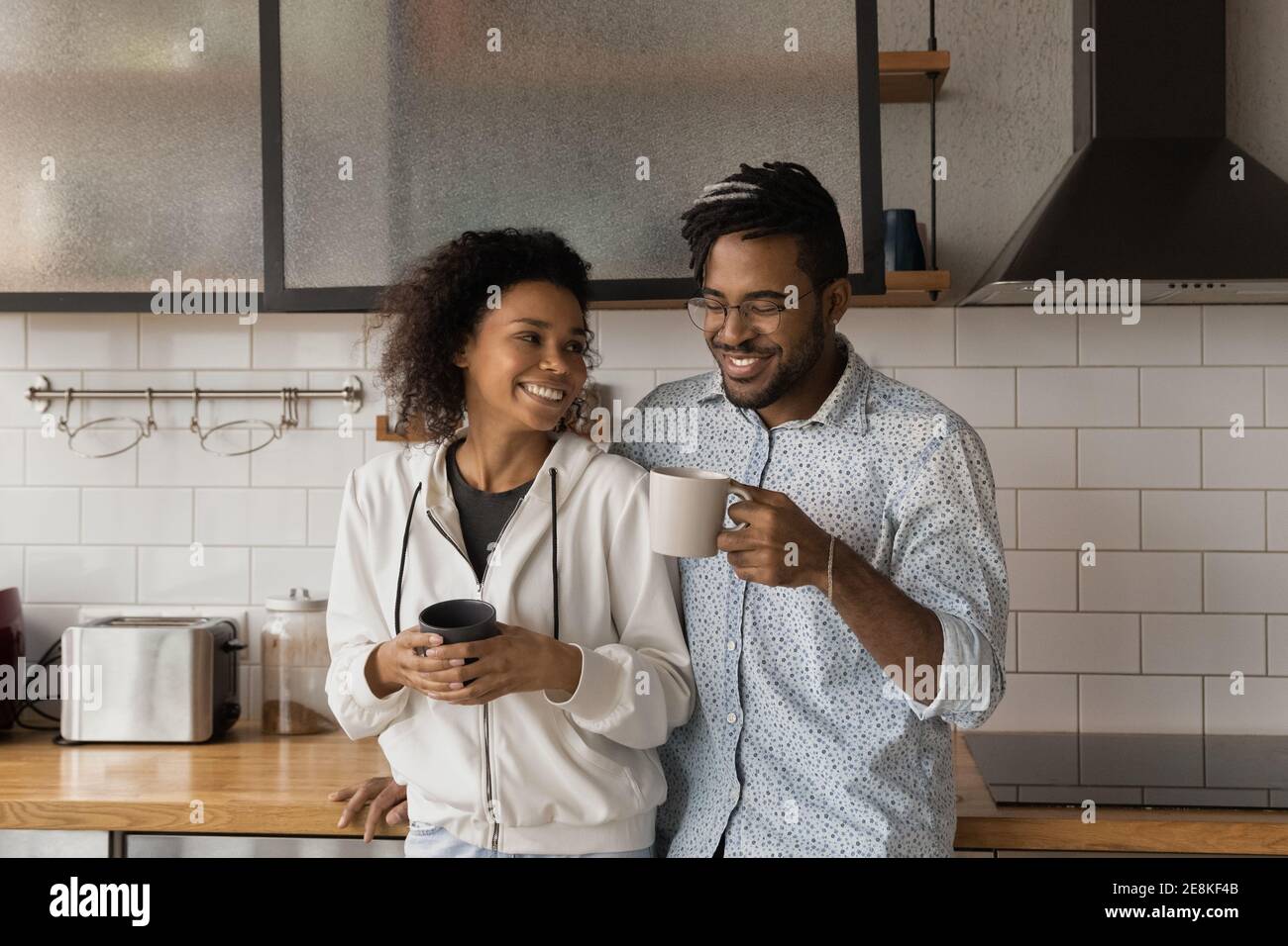 Millennial african pärchen im Gespräch genießen heiße Getränke in der gemütlichen Küche Stockfoto