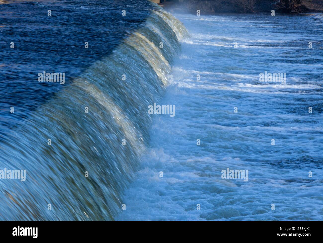 Winter Nahaufnahme des Wassers, das über einem Wehr fließt Am Fluss Wharfe in Yorkshire Stockfoto
