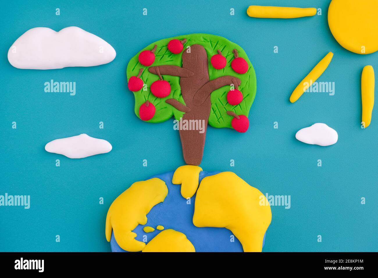 Ein Apfelbaum, der auf der Erde wächst. Die Szene besteht aus Fimo. Stockfoto