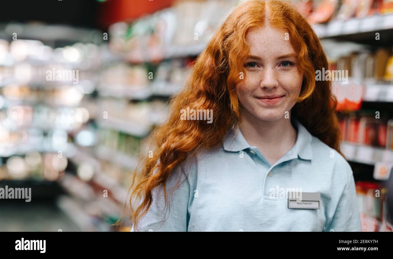 Porträt einer jungen Supermarktarbeiterin. Frau auf einem Ferienjob im Lebensmittelgeschäft. Stockfoto
