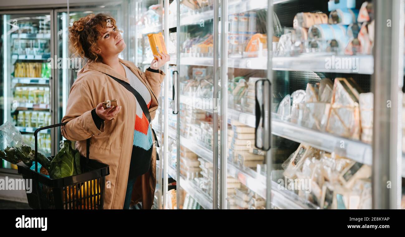 Frau kauft Lebensmittel aus einem Supermarkt. Weibliche Kunden einkaufen im Supermarkt. Stockfoto