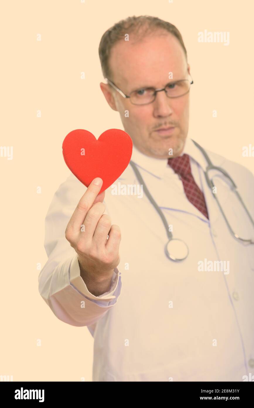 Studio geschossen von reifer Mann Arzt halten roten Herzen mit Fokus auf Herz Stockfoto
