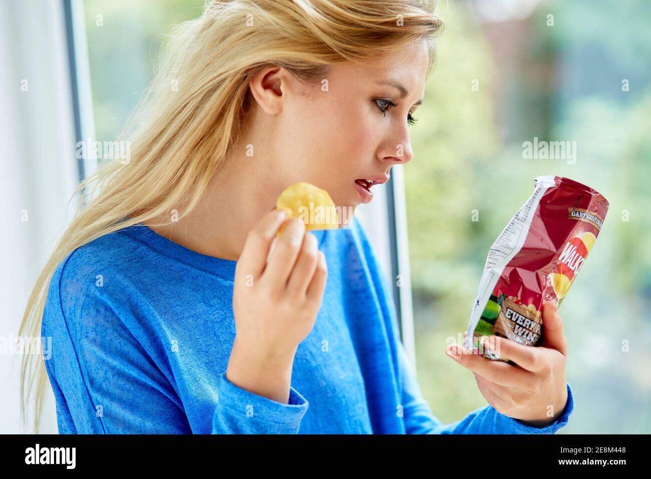 Mädchen essen eine Tüte Chips Stockfoto