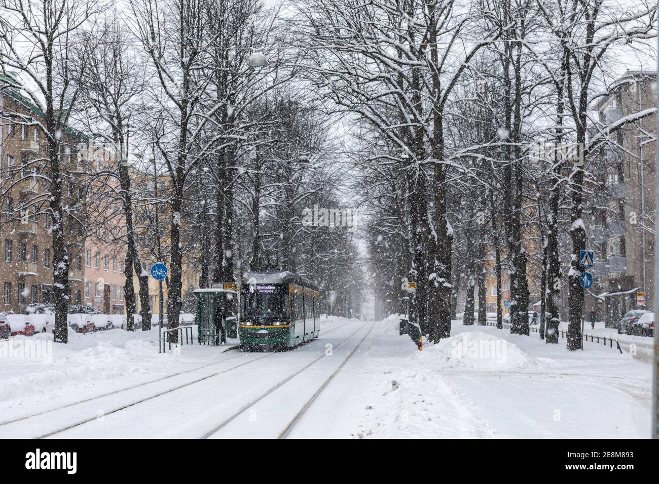 Tram 463 der Linie 4 bei Munkkiniemen puitstitie Haltestelle bei starkem Schneefall im Munkkiniemi Bezirk von Helsinki, Finnland Stockfoto