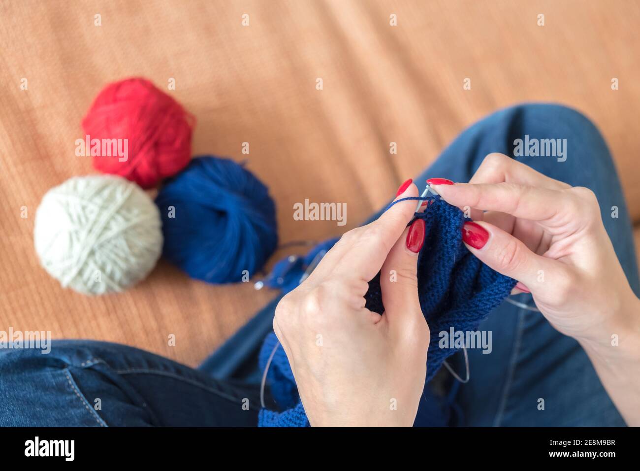 Nahaufnahme von weiblichen Händen Stricken einen blauen Schal. Stockfoto