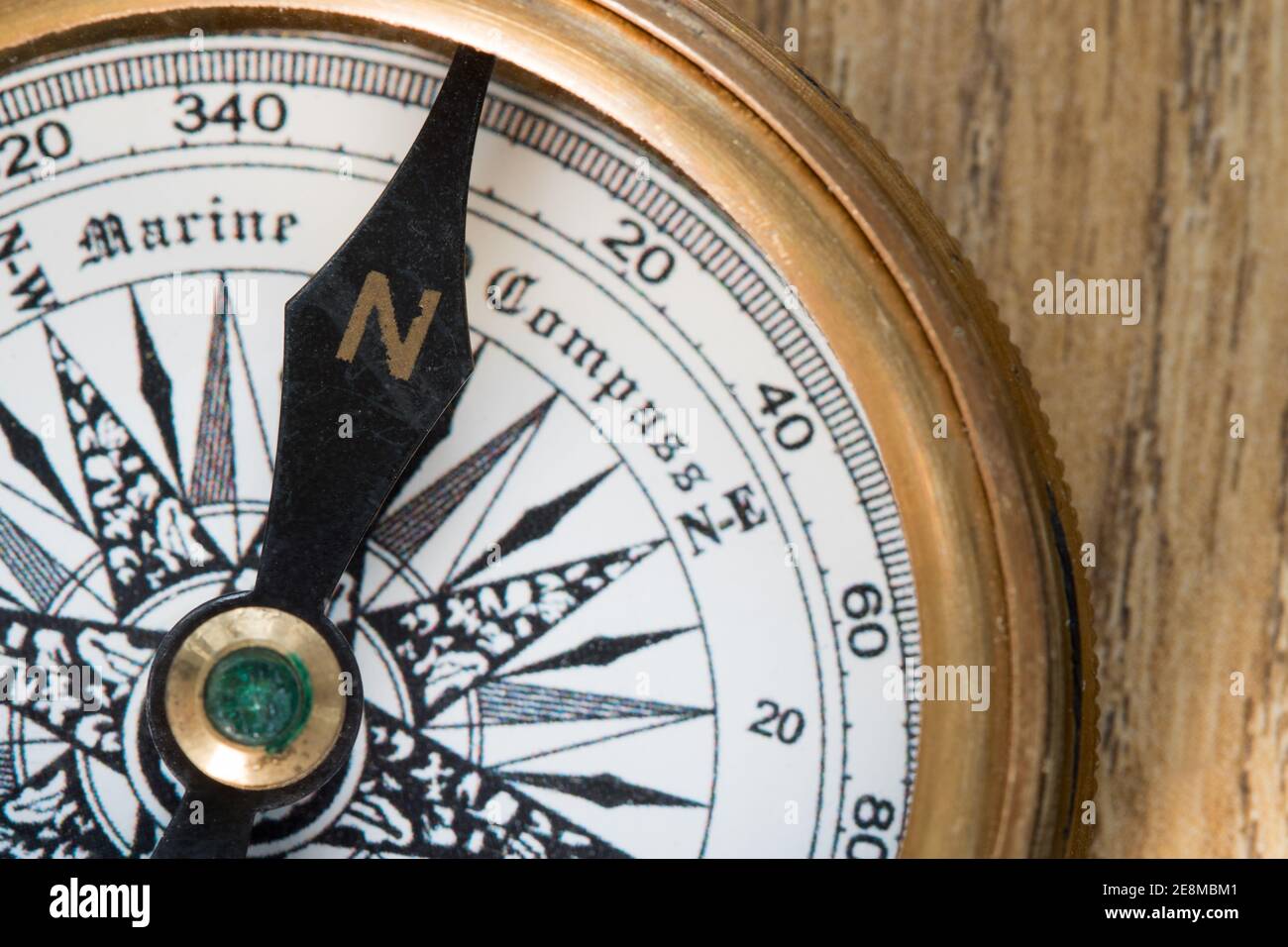 Altmodischer Kompass, der nach Norden auf einem Holzdeck zeigt Plank Stockfoto